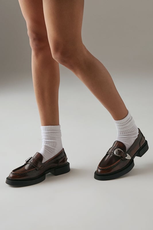 Genuine leather upper for durability and style
        Western-inspired buckle detail adds a unique touch
        Chunky sole provides comfort and a trendy look
        Flat heel (0-2cm) ensures all-day wearability
        Versatile loafer design suitable for various occasions
    
    Step out in confidence with these Faith for Warehouse leather loafers. The western buckle detail adds a dash of intrigue to the classic silhouette, while the chunky sole offers both style and substance. Perfect for the fashion-forward woman who values comfort without compromising on style. Pair these versatile flats with tailored trousers and a crisp white shirt for a smart casual look at the office, or team them with a flowing midi dress for weekend brunches. The rich leather upper will develop a beautiful patina over time, making these loafers a cherished addition to your wardrobe. Whether you're navigating city streets or attending casual gatherings, these loafers will keep you looking polished and feeling comfortable all day long.