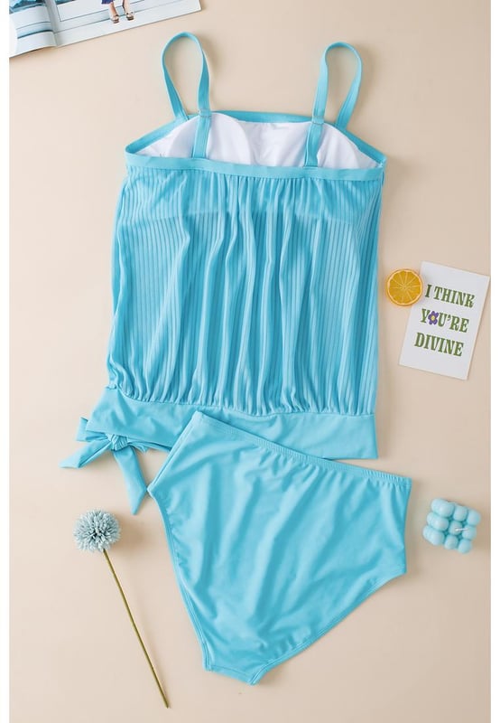 Our styles are designed with a trendy fitted look in mind following an international size standard. For the best fit we suggest choosing one size up from your usual. Be sure to check our sizing chart to find your perfect match!
  Flattering and stylish tankini
  Turquoise striped mesh design
  Trendy knotted hem detail on the top
  High
  rise design for easy pull
  on
  Adjustable straps for a customizable fit
  Removable padded cups for added support and coverage
  Versatile tankini suitable for pairing with coverups
Material: 82% Polyamide 18% Elastane