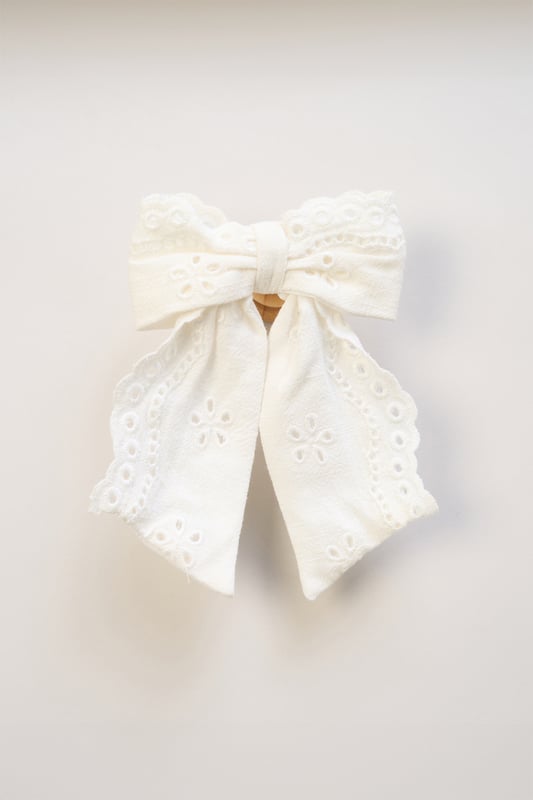 This floaty broderie dress by Miss, featuring delicate crochet panel detailing, is a versatile wardrobe must-have. Paired with a matching bow hair clip and finished with a classic denim jacket, it's perfect for breezy days and stylish outings.