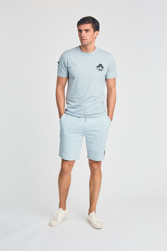 The Tokyo Laundry Logo Beach Set features a printed palm tree design on both the t-shirt and jogger shorts. Ideal for summer holidays, this comfortable, lightweight set is perfect for beach days and warm-weather adventures. A stylish and relaxed choice for your summer wardrobe.