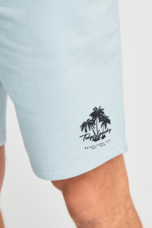 The Tokyo Laundry Logo Beach Set features a printed palm tree design on both the t-shirt and jogger shorts. Ideal for summer holidays, this comfortable, lightweight set is perfect for beach days and warm-weather adventures. A stylish and relaxed choice for your summer wardrobe.