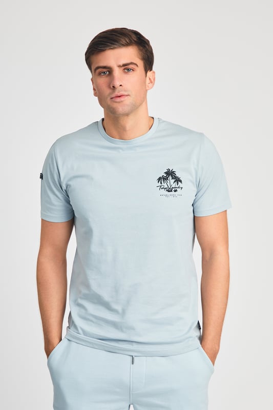 The Tokyo Laundry Logo Beach Set features a printed palm tree design on both the t-shirt and jogger shorts. Ideal for summer holidays, this comfortable, lightweight set is perfect for beach days and warm-weather adventures. A stylish and relaxed choice for your summer wardrobe.