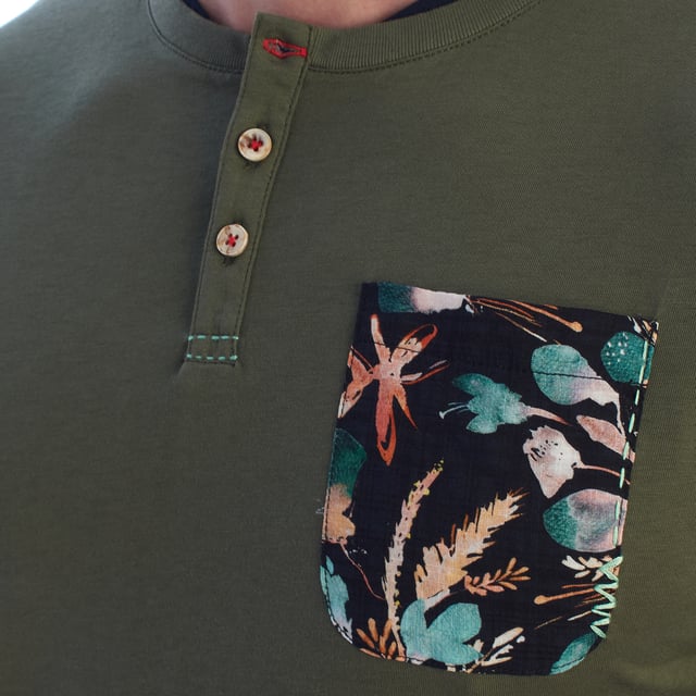 Esta camiseta Henley de manga corta fusiona lo mejor del estilo relajado con un toque artístico. Elaborada con algodón de alta calidad, presenta un cuello redondo y una tapicería con tres botones, añadiendo una sensación casual pero cuidadosamente estructurada. El bolsillo en el pecho cuenta con un estampado abstracto multicolor que aporta contraste y originalidad a esta camiseta para hombre.

Detalles:
- Cuello Henley con tapicería de botones personalizada.
- Corte regular.
- Bolsillo en el pecho con estampado artístico.
- Acabado de interior en tela acanalada de contraste en el cuello.
- Manga corta con doblez limpio.
- Tejido de algodón suave, transpirable y cómodo.
- Etiqueta decorativa en la parte inferior.

Añade un toque moderno a tu guardarropa con esta camiseta Henley para hombre con un bolsillo estampado. Ideal para quienes buscan un equilibrio entre comodidad, originalidad y estilo casual, esta camiseta es perfecta tanto para el uso diario como para looks más pulidos sin sacrificar el estilo.  
Composición: 100% algodón  
Cuidado:  
Lavar a máquina a 30 °C.  
No usar blanqueador ni secadora.  
Planchar a baja temperatura del revés.