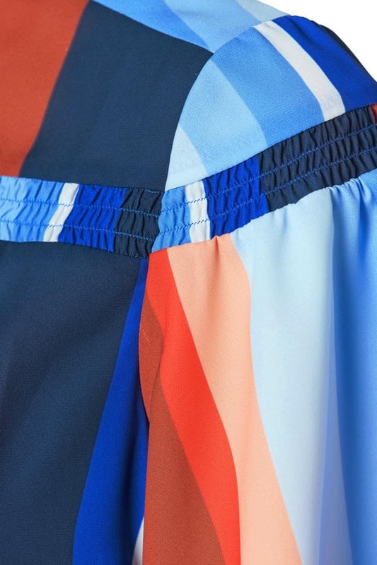 Met de vrolijke Waylon print blouse van Mart Visser straal je deze zomer stijl uit. Deze damesblouse heeft een openvallende kraag en is gemaakt van een kwaliteit die soepel om je lichaam valt. De heuplange blouse is voorzien van afgeronde splitten en korte vlindermouwen. Let vooral op het smockdetail rondom de bovenkant van de blouse, wat zorgt voor een speels effect en een designer touch. De blouse sluit met een blinde knoopsluiting en de valling van de multicolor stof maakt elke blouse uniek. Mart ziet zijn blouse het liefst gedragen met een witte jeans. Fan van de Waylon print? Bekijk dan ook de Gillian cirkel jurk gemaakt van dezelfde kleurrijke stof. Je kunt ook de Mave top overwegen, die dezelfde pasvorm heeft maar is gemaakt van een effen marineblauwe stof. Flaneer deze zomer in de stijlvolle Mart Visser top, op het terras of op kantoor.