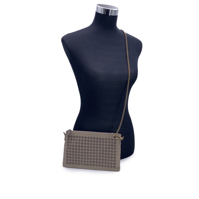 VINTAGE, RRP AS NEW
Elegant in its simplicity and rich in texture, this Bottega Veneta taupe leather zip pouch bag is a refined expression of the house's iconic craftsmanship. The front features Bottega's signature Intrecciato woven leather, a tactile nod to artisanal tradition, contrasted beautifully by the smooth leather body.  The bag opens with a sleek upper zipper closure, revealing a plush brown suede interior thoughtfully designed with six open side pockets and one larger slip pocket-perfectly organized for essentials. A removable gold-tone chain strap adds a touch of versatility and understated glamour.  Inside, the 'Bottega Veneta - Made in Italy' engraving stands as a quiet testament to its heritage-proof that timeless design never shouts, it whispers. Condition Rating: A - EXCELLENTCondition Details: Some light scratches on leather due to normal use. Please check the photos carefully and ask if you need to know more details or if you have any doubts.Measurements (cm):Depth: 2.5Height: 15.2Length: 24.1Other Details: Dustbag? YesKeys? NoBox? No Measurments:  width: 25 mm length: 241 mm height: 152 mm