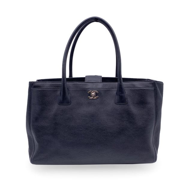 VINTAGE, RRP AS NEW
Stunning Chanel 'Executive' Tote Bag in black pebbled leather. Period/Era: 2010/2011. Silver metal CC - CHANEL logo on the front. Double top handles and removable shoulder strap. Double magnetic button closure on top. Front and rear pocket. Black grosgrain lining. 2 side zip pockets inside and a fabric removable pouch inside. 'Chanel - Made in Italy' tag inside. ity hologram tag inside. Condition Rating: A - EXCELLENTCondition Details: Gently used. Minimal wear of use on bottom corners. Please, check carefully the photos or ask if you have any doubts.Measurements (cm):Depth: 15.2Height: 22.9Length: 35.6Other Details: Dustbag? YesKeys? NoBox? Yes Measurments:  width: 152 mm length: 356 mm height: 229 mm