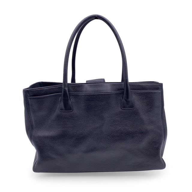 VINTAGE, RRP AS NEW
Stunning Chanel 'Executive' Tote Bag in black pebbled leather. Period/Era: 2010/2011. Silver metal CC - CHANEL logo on the front. Double top handles and removable shoulder strap. Double magnetic button closure on top. Front and rear pocket. Black grosgrain lining. 2 side zip pockets inside and a fabric removable pouch inside. 'Chanel - Made in Italy' tag inside. ity hologram tag inside. Condition Rating: A - EXCELLENTCondition Details: Gently used. Minimal wear of use on bottom corners. Please, check carefully the photos or ask if you have any doubts.Measurements (cm):Depth: 15.2Height: 22.9Length: 35.6Other Details: Dustbag? YesKeys? NoBox? Yes Measurments:  width: 152 mm length: 356 mm height: 229 mm