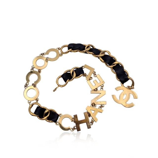 VINTAGE, RRP AS NEW
Rare statement vintage wide chain belt by CHANEL. Period/Era: 1993. It is crafted in gold metal with black interwoven leather. It features a spell out C O C O C H A N E L letters. CC logo pendant at theend of the belt. Hook closure. Marked with 'CHANEL 93 CC P Made in France' oval hallmark. Total lensth of the chain: 36 inches - 91.5 cm Condition Rating: B - VERY GOOD CONDITIONCondition Details: A light patina, minimal darkness and light surface scratches on the letters and the chain link. Chanel dustbag included. Please check the photos carefully and ask if you need to know more details or if you have any doubts.  Box?: Measurments:  length: 915 mm