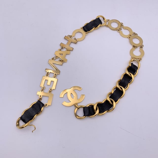 VINTAGE, RRP AS NEW
Rare statement vintage wide chain belt by CHANEL. Period/Era: 1993. It is crafted in gold metal with black interwoven leather. It features a spell out C O C O C H A N E L letters. CC logo pendant at theend of the belt. Hook closure. Marked with 'CHANEL 93 CC P Made in France' oval hallmark. Total lensth of the chain: 36 inches - 91.5 cm Condition Rating: B - VERY GOOD CONDITIONCondition Details: A light patina, minimal darkness and light surface scratches on the letters and the chain link. Chanel dustbag included. Please check the photos carefully and ask if you need to know more details or if you have any doubts.  Box?: Measurments:  length: 915 mm