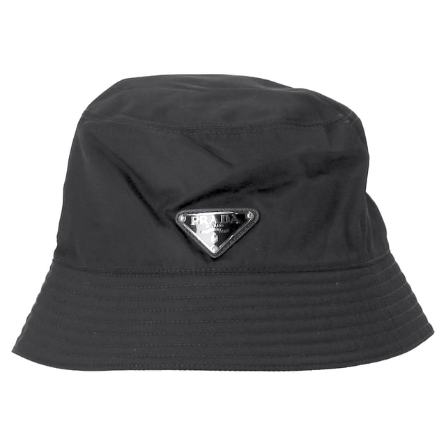 VINTAGE, UVP WIE NEU  
Setzen Sie ein Statement, während Sie stilvoll vor der Sonne geschützt sind, mit dem Prada Re-Nylon Metal Triangle Logo Bucket Hat aus schwarzem Nylon. Hergestellt aus strapazierfähigem, nachhaltigem Re-Nylon-Stoff, verfügt dieser schicke Bucket Hat über das charakteristische silberne und schwarze emaillierte Prada-Logo auf der Vorderseite, das Ihrem Look einen Hauch zeitgenössischer Luxus verleiht. Das schlanke Design und das funktionale Material machen ihn zu einem unverzichtbaren Accessoire für jede modebewusste Frau, die Praktikabilität mit hochwertigem Stil verbinden möchte.  

Prada Re-Nylon Metal Triangle Logo Bucket Hat aus schwarzem Nylon  
Zustand: Ausgezeichnet  
Abnutzungsspuren: Keine Abnutzungsspuren.  
Verpackung: Keine  
Farbe: schwarz  
Material: Nylon  
Größe: INT | S  
Maße: Höhe: 100; Länge: 550  
SKU: NAPPUDEAC466125W