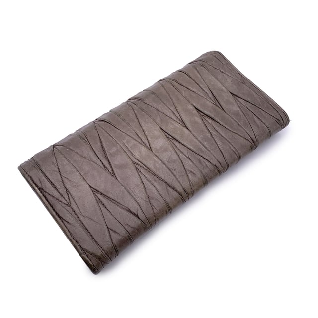 VINTAGE, RRP WIE NEU  
Elegant und mit einem Hauch von Kante, ist dieses Miu Miu Continental Wallet ein verfeinerter Klassiker, eingehüllt in taupefarbenes Matelassé-Leder mit einem subtilen, abgenutzten Effekt, der genau den richtigen Charakter zu seiner eleganten Silhouette hinzufügt. Das ikonische goldene MIU MIU-Logo glänzt auf dem Verschluss, der mit einem dezenten Knopf gesichert ist. Öffnen Sie es, um ein durchdacht gestaltetes Inneres zu enthüllen: 12 Kreditkartenfächer, zwei geräumige Fächer, ein Münzfach mit Reißverschluss und eine seitliche offene Sektion, die ordentlich unter dem Verschluss verborgen ist. Innen ist 'MIU MIU' in das Leder eingeprägt, mit einer Seriennummer, die als leise Markierung der Authentizität dient. Unaufdringlich und endlos schick, ist dieses Stück mehr als nur eine Geldbörse – es ist ein kleines Stück von Miu Mius verspielter Eleganz, das dazu gemacht ist, getragen und geschätzt zu werden.  
Zustandsbewertung: B - SEHR GUTER ZUSTAND  
Zustandsdetails: Sanft gebraucht. Einige leichte Kratzer auf dem Leder aufgrund normalen Gebrauchs. Miu Miu-Box enthalten. Bitte überprüfen Sie die Fotos sorgfältig und fragen Sie, wenn Sie mehr Details wissen möchten oder Zweifel haben.  
Maße (cm): Höhe: 10,2 Länge: 19,1  
Box?: Ja  
Maße: Länge: 191 mm Höhe: 102 mm