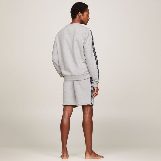 Men's Tommy Hilfiger Logo Tape Lounge Sweatshirt in Grey Ribbed crewneck.Ribbed cuffs and hem.TH logo stripes on the sleeves.Tommy Hilfiger flag embroidery on the chest.Regular fit.