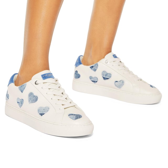 The
Lane Love sneaker is crafted from a white leather with denim cut out hearts
across the upper. There are two blue suede patches on the tongue and heel with
gold foil branding.