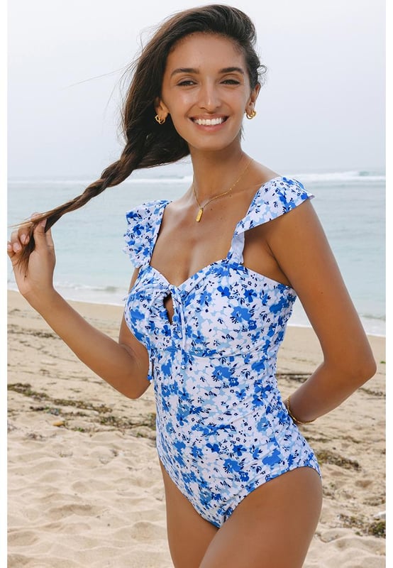 Our styles are designed with a trendy fitted look in mind following an international size standard. For the best fit we suggest choosing one size up from your usual. Be sure to check our sizing chart to find your perfect match!
  Vibrant blue floral print
  Ruffled straps
  Hollow
  out front design
  Lace
  up detail
  Available in sizes S to XL
  High elasticity for a comfortable fit
Material: 85% Polyester 15% Elastane