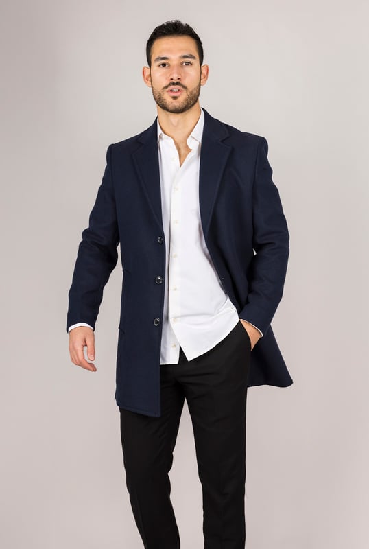 Abrigo de mezcla de lana azul marino con cuello de solapa con muesca para hombre Entra en las estaciones más frías con confianza en este clásico abrigo de mezcla de lana, diseñado para combinar la elegancia atemporal con la sastrería moderna. Confeccionado con una mezcla de lana y licra de alta calidad, ofrece calidez y durabilidad. El cuello de solapa con muesca añade un toque refinado y profesional, mientras que el cierre tradicional de 3 botones garantiza un ajuste seguro y elegante. Con una silueta entallada que favorece sin restringir el movimiento, este abrigo es ideal tanto para ocasiones formales como para el uso diario sofisticado. Cierre clásico de 3 botones: Cierre tradicional para un acabado seguro y elegante. Ajuste entallado: Proporciona una silueta elegante y estructurada con una comodidad duradera. Cuello de solapa con muesca: Añade un toque de sofisticación y versatilidad. Tejido de mezcla de lana: Hecho de 65 % lana y 35 % licra para mayor calidez y resistencia. Composición del material: 65 % lana, 35 % licra.