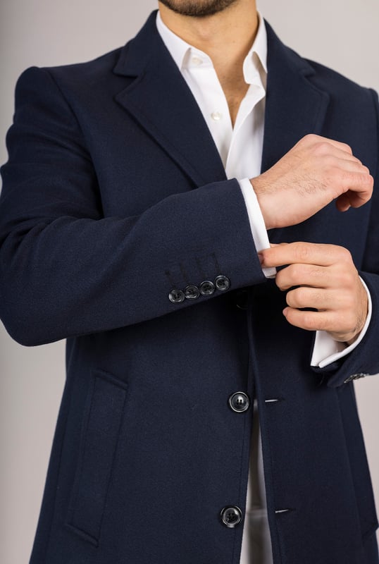 Abrigo de mezcla de lana azul marino con cuello de solapa con muesca para hombre Entra en las estaciones más frías con confianza en este clásico abrigo de mezcla de lana, diseñado para combinar la elegancia atemporal con la sastrería moderna. Confeccionado con una mezcla de lana y licra de alta calidad, ofrece calidez y durabilidad. El cuello de solapa con muesca añade un toque refinado y profesional, mientras que el cierre tradicional de 3 botones garantiza un ajuste seguro y elegante. Con una silueta entallada que favorece sin restringir el movimiento, este abrigo es ideal tanto para ocasiones formales como para el uso diario sofisticado. Cierre clásico de 3 botones: Cierre tradicional para un acabado seguro y elegante. Ajuste entallado: Proporciona una silueta elegante y estructurada con una comodidad duradera. Cuello de solapa con muesca: Añade un toque de sofisticación y versatilidad. Tejido de mezcla de lana: Hecho de 65 % lana y 35 % licra para mayor calidez y resistencia. Composición del material: 65 % lana, 35 % licra.