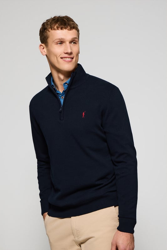 Verleihen Sie Ihrem Look eine raffinierte Note mit unserem Strickpullover aus Baumwolle für Herren. Er verfügt über einen praktischen halben Reißverschluss und gerippte Details an Kragen, Ärmeln und Taille für einen perfekten Sitz und eine ideale Passform. Das dezente marineblaue Nahtband am Kragen mit eingraviertem Polo Club Logo unterstreichen die Eleganz dieses Pullovers. Charakteristische Stickerei unseres Rigby Go-Logos in Kontrastfarbe auf der Brust. Ein vielseitiges Kleidungsstück, das sowohl zu einem lässigen als auch zu einem formelleren Look passt.