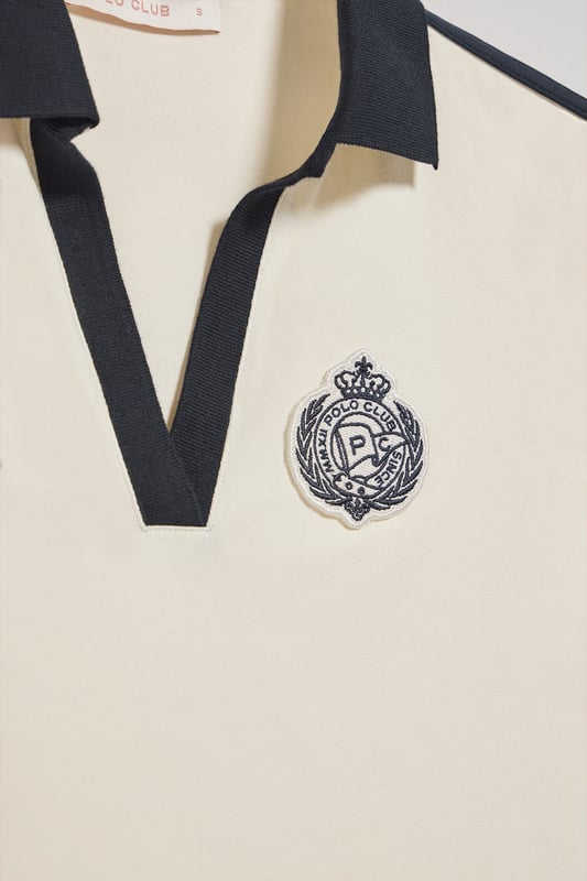 Das maritim inspirierte, kurzärmelige Damen-Poloshirt verbindet den klassischen Polostil mit modernen Details. Die samtige Baumwollverarbeitung verleiht ihm eine einzigartige Weichheit. Der elegante V-Ausschnitt mit kontrastierendem Revers verleiht dem Poloshirt einen raffinierten Look. Die Seitenschlitze setzen nicht nur einen modernen Akzent, sondern optimieren auch die Passform. Nahtband an der Krageninnenseite. Der einfarbige Aufnäher mit nautischem Motiv auf der Brust rundet das Design ab. Ideal, um einen Tag im Freien zu genießen.