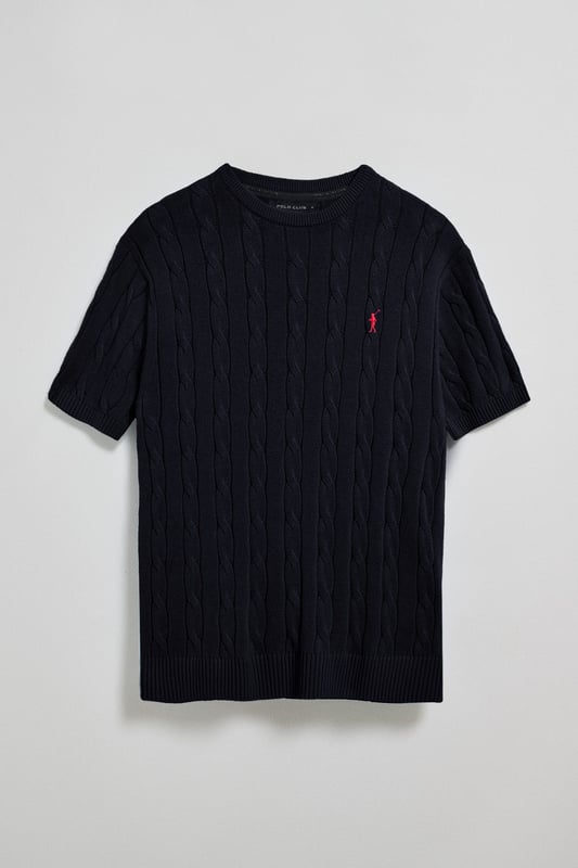 Unser kurzärmliger Zopfstrickpullover für Herren ist eine Neuheit in unserer Zopfmuster-Kollektion für diese Saison. Sein einzigartiges Flechtmuster verleiht ihm Struktur und Raffinesse, während gerippte Details an Kragen, Ärmeln und Saum für einen guten Sitz und ein elegantes Finish sorgen. Das dezente marineblaue Nahtband am Kragen mit Polo Club Logo unterstreicht die Eleganz dieses Modells. Die emblematische Rigby Go Stickerei in Kontrastfarbe auf der Brust unterstreicht seine einzigartige Optik. Ideal für einen eleganten und zeitlosen Look.