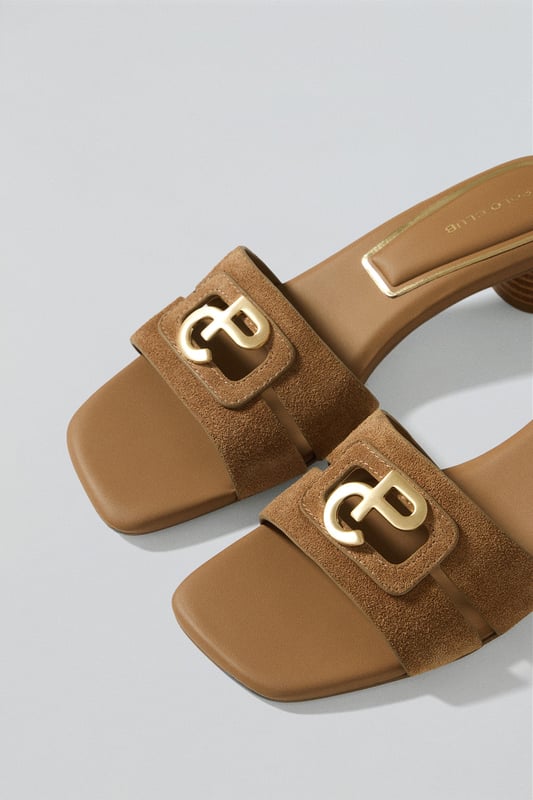 Entdecken Sie die zeitlose Eleganz der Mules mit Absatz Giorgia aus Veloursleder mit einem raffinierten goldfarbenen PC-Monogramm auf dem Oberleder. Die verzierte und gepolsterte Innensohle und die rutschfeste Sohle garantieren absoluten Komfort, während der Absatz von ca. 4,5 cm die perfekte Balance zwischen Stil und Komfort bietet.