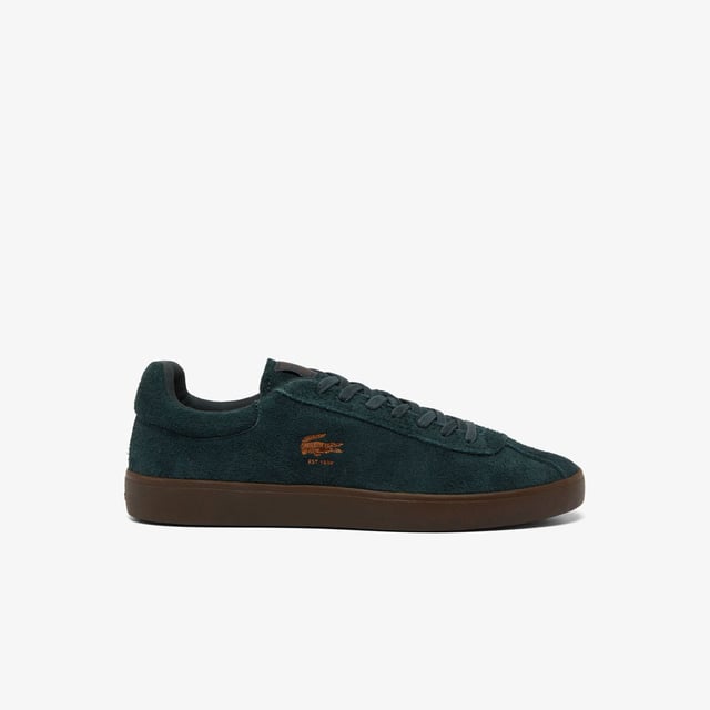 Men's Lacoste Baseshot Suede Trainers in Green Men's Baseshot Suede Sneakers Premium suede upper Padded collar for increased comfort and support Vintage tennis label on tongue Supple high-grip rubber outsole Debossed retro crocodile on front panel