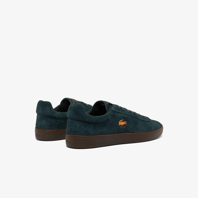 Men's Lacoste Baseshot Suede Trainers in Green Men's Baseshot Suede Sneakers Premium suede upper Padded collar for increased comfort and support Vintage tennis label on tongue Supple high-grip rubber outsole Debossed retro crocodile on front panel
