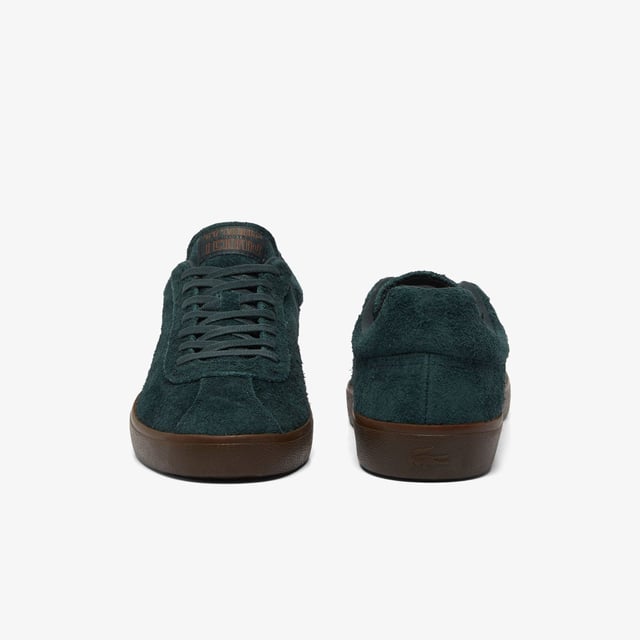 Men's Lacoste Baseshot Suede Trainers in Green Men's Baseshot Suede Sneakers Premium suede upper Padded collar for increased comfort and support Vintage tennis label on tongue Supple high-grip rubber outsole Debossed retro crocodile on front panel