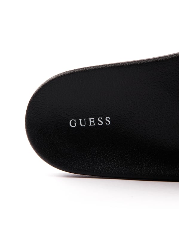 Guess Tokyom Herren Pantoletten Schwarz Synthetik. Authentischer Schuh der Marke Guess - Streetwear/Sportswear Design von Guess - Guess für modebewusste Männer, perfekt für den Alltag - Die schwarzen Guess Pantoletten lassen sich ideal mit dem Rest Ihrer Garderobe kombinieren - Bequeme Synthetikmaterial - Klassische Schnalle - Tokyom - Synthetik