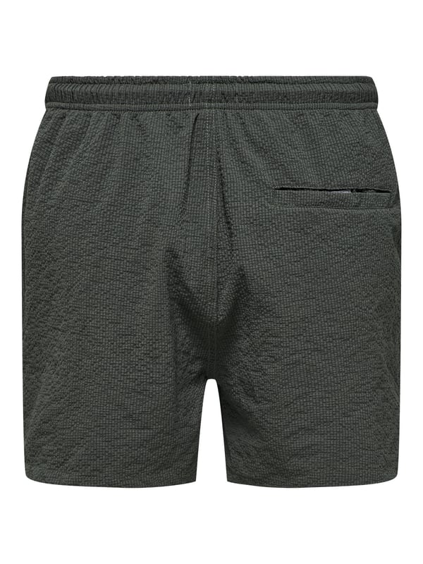 Met deze badshorts geniet je van zomers comfort in een stijlvolle ontwerp. De elastische tailleband met tunnelkoord zorgt voor een veilige pasvorm, terwijl de normale pasvorm en de middelhoge taille optimale bewegingsvrijheid bieden. Zijzakken en een achterzak maken de shorts ook praktisch. De lichte seersucker-stof voelt prettig aan op de huid en geeft de look een gestructureerde uitstraling. Een subtiele gulp en het geweven label aan de binnenkant ronden het ontwerp discreet af – perfect voor ontspannen dagen aan het water.
