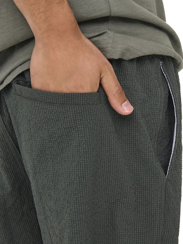 Met deze badshorts geniet je van zomers comfort in een stijlvolle ontwerp. De elastische tailleband met tunnelkoord zorgt voor een veilige pasvorm, terwijl de normale pasvorm en de middelhoge taille optimale bewegingsvrijheid bieden. Zijzakken en een achterzak maken de shorts ook praktisch. De lichte seersucker-stof voelt prettig aan op de huid en geeft de look een gestructureerde uitstraling. Een subtiele gulp en het geweven label aan de binnenkant ronden het ontwerp discreet af – perfect voor ontspannen dagen aan het water.
