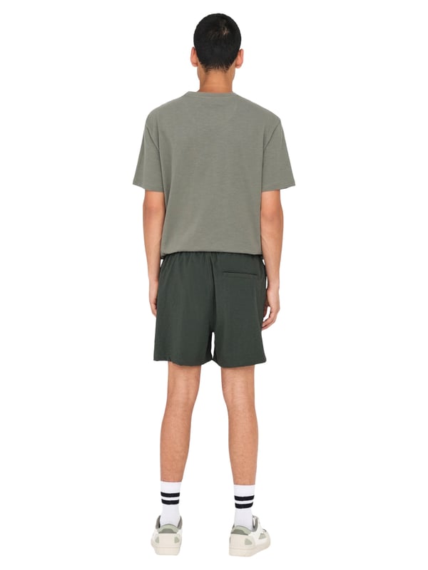 Met deze badshorts geniet je van zomers comfort in een stijlvolle ontwerp. De elastische tailleband met tunnelkoord zorgt voor een veilige pasvorm, terwijl de normale pasvorm en de middelhoge taille optimale bewegingsvrijheid bieden. Zijzakken en een achterzak maken de shorts ook praktisch. De lichte seersucker-stof voelt prettig aan op de huid en geeft de look een gestructureerde uitstraling. Een subtiele gulp en het geweven label aan de binnenkant ronden het ontwerp discreet af – perfect voor ontspannen dagen aan het water.