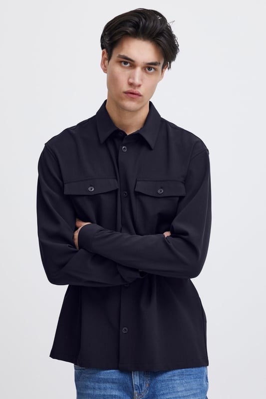La sobrecamisa Chris - Dark Navy es la combinación perfecta de estilo y funcionalidad para hombres. Esta sobrecamisa está diseñada para encajar en cualquier guardarropa con su atemporal color azul oscuro y su expresión versátil. Confeccionado con 63 por ciento de poliéster, 33 por ciento de viscosa y 4 por ciento de elastano, garantiza un ajuste duradero y cómodo. Perfecto tanto para el uso diario como para ocasiones especiales, y se puede colocar fácilmente sobre una camiseta o debajo de una chaqueta. Con la sobrecamisa Chris no solo obtendrás una apariencia elegante, sino también una prenda diseñada para durar.