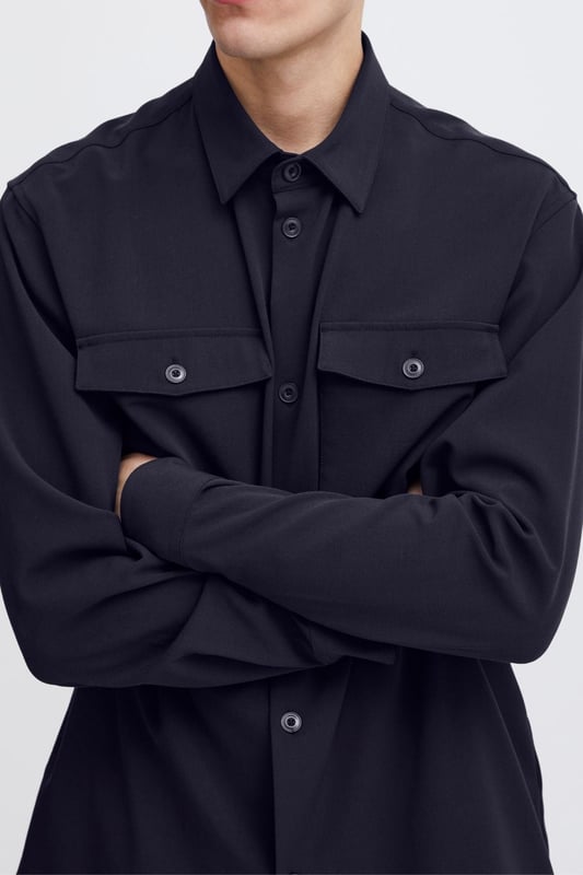 La sobrecamisa Chris - Dark Navy es la combinación perfecta de estilo y funcionalidad para hombres. Esta sobrecamisa está diseñada para encajar en cualquier guardarropa con su atemporal color azul oscuro y su expresión versátil. Confeccionado con 63 por ciento de poliéster, 33 por ciento de viscosa y 4 por ciento de elastano, garantiza un ajuste duradero y cómodo. Perfecto tanto para el uso diario como para ocasiones especiales, y se puede colocar fácilmente sobre una camiseta o debajo de una chaqueta. Con la sobrecamisa Chris no solo obtendrás una apariencia elegante, sino también una prenda diseñada para durar.