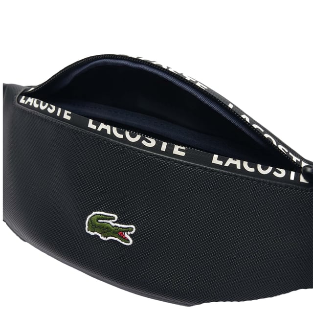 Leinen. Marke: Lacoste. Länge: 35 cm. Höhe: 10,5 cm. Tiefe: 7 cm. Taschenart: 1 Tasche hinten, Reißverschluss. Fächer: 1 Hauptfach. Taschenmerkmale: Verstellbarer Hüftgurt. Design: Gesticktes Logo, Mit Streifen. Reißverschluss.