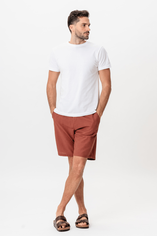 Experimenta la comodidad del verano con nuestros pantalones cortos de lino en el cálido color Terracota, especialmente diseñados para hombres. Estos pantalones cortos están confeccionados con un 70 por ciento de algodón y un 30 por ciento de lino, lo que les da una sensación de luminosidad y ventilación, perfectos para los días calurosos. El diseño clásico y atemporal los hace ideales tanto para vestir casual como con estilo. Ya sea que estés en la ciudad o en la playa, te garantizan un ajuste moderno y cómodo.
