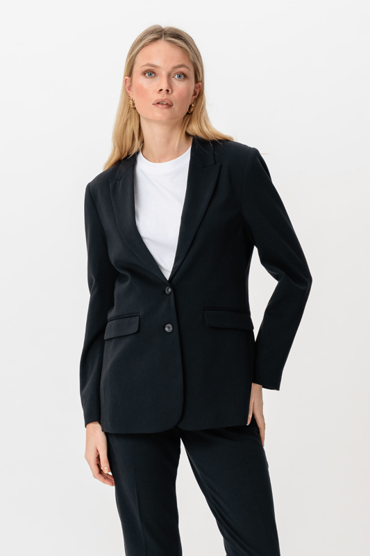 Este Performance Blazer en azul marino es la elección perfecta para las mujeres modernas que desean combinar estilo y comodidad. Está confeccionado para un ajuste perfecto que acentúa tu silueta manteniendo la libertad de movimiento. Diseñado con 75% poliéster, 22% viscosa y 3% elastano, el blazer garantiza una experiencia de uso duradera y cómoda. Este diseño atemporal lo hace adecuado tanto para ocasiones laborales como sociales. Combina la chaqueta con un par de pantalones o un vestido para un look elegante. Es una adición esencial a tu guardarropa, ya que ofrece versatilidad y un aspecto moderno y elegante.