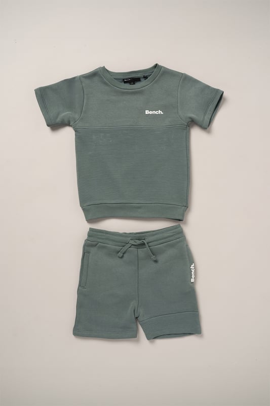 This Bench set combines a short sleeve sweatshirt with matching shorts, made from soft brushed sweat fabric for all-day comfort. Featuring ottoman rib panelling and elasticated rib hems, the outfit blends durability with a premium finish. A flat woven drawcord adds a practical detail, making this set a go-to for casual wear with a stylish edge.