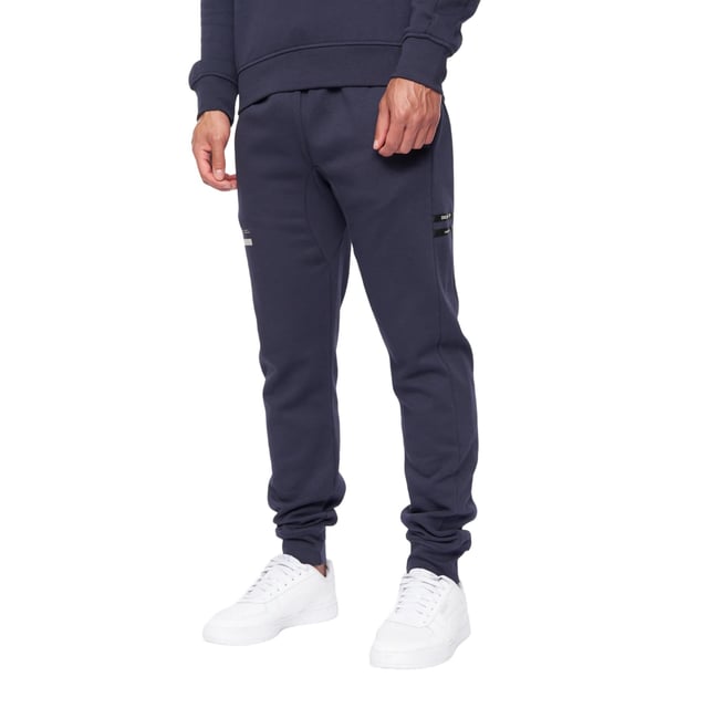 65% Baumwolle, 35% Elastan. Design: Logo. Gewebetechnik: Atmungsaktiv. Taschenart: Zwei Seitentaschen. Taille: mit Kordelzug, Elastisch. Passform: Schmal zulaufend. Saum: Anliegend.