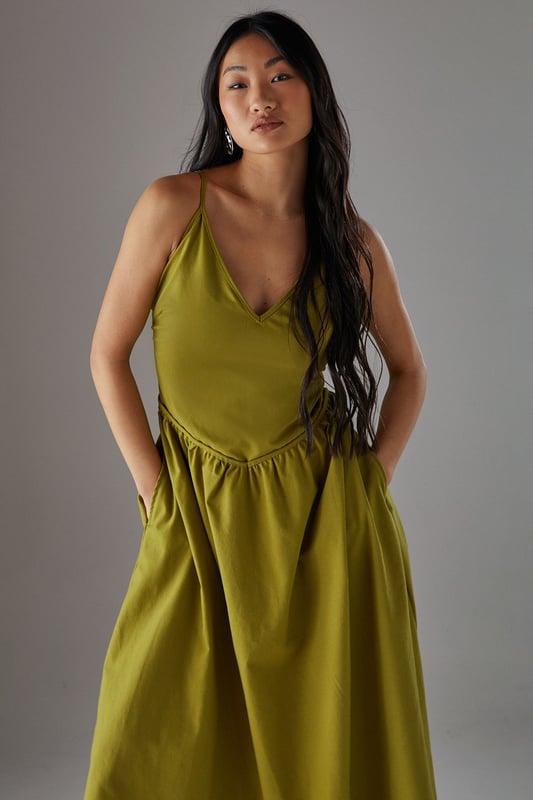 Linen blend midi sundress with flattering plunge neckline
        Adjustable spaghetti straps for a personalised fit
        Gathered waist detail creating a feminine silhouette
        Practical side pockets for everyday functionality
        Fully lined for comfort and ease of wear
    
    This effortlessly chic sundress from Warehouse combines casual comfort with sophisticated style. The plunge neckline adds a touch of allure while the gathered waist creates a flattering shape that complements the flowing midi length. Perfect for warm-weather occasions, style with flat sandals as seen on our model for a relaxed daytime look, or dress up with espadrille wedges and statement earrings for garden parties. The linen blend fabric offers a natural drape that moves beautifully with you, making it ideal for summer strolls or casual brunches with friends. The versatile design works equally well with a denim jacket for cooler evenings or worn alone to showcase its elegant simplicity. A wardrobe essential that transitions seamlessly from city breaks to countryside weekends.