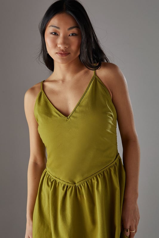 Linen blend midi sundress with flattering plunge neckline
        Adjustable spaghetti straps for a personalised fit
        Gathered waist detail creating a feminine silhouette
        Practical side pockets for everyday functionality
        Fully lined for comfort and ease of wear
    
    This effortlessly chic sundress from Warehouse combines casual comfort with sophisticated style. The plunge neckline adds a touch of allure while the gathered waist creates a flattering shape that complements the flowing midi length. Perfect for warm-weather occasions, style with flat sandals as seen on our model for a relaxed daytime look, or dress up with espadrille wedges and statement earrings for garden parties. The linen blend fabric offers a natural drape that moves beautifully with you, making it ideal for summer strolls or casual brunches with friends. The versatile design works equally well with a denim jacket for cooler evenings or worn alone to showcase its elegant simplicity. A wardrobe essential that transitions seamlessly from city breaks to countryside weekends.