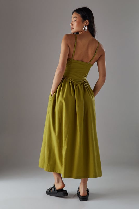 Linen blend midi sundress with flattering plunge neckline
        Adjustable spaghetti straps for a personalised fit
        Gathered waist detail creating a feminine silhouette
        Practical side pockets for everyday functionality
        Fully lined for comfort and ease of wear
    
    This effortlessly chic sundress from Warehouse combines casual comfort with sophisticated style. The plunge neckline adds a touch of allure while the gathered waist creates a flattering shape that complements the flowing midi length. Perfect for warm-weather occasions, style with flat sandals as seen on our model for a relaxed daytime look, or dress up with espadrille wedges and statement earrings for garden parties. The linen blend fabric offers a natural drape that moves beautifully with you, making it ideal for summer strolls or casual brunches with friends. The versatile design works equally well with a denim jacket for cooler evenings or worn alone to showcase its elegant simplicity. A wardrobe essential that transitions seamlessly from city breaks to countryside weekends.