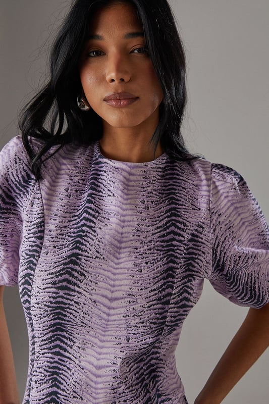 Striking animal print twill fabric with textured finish
        Feminine puff sleeves add volume and contemporary flair
        Tiered ruffle hem creates movement and dimension
        Midi length offers versatile styling options
        Relaxed silhouette with round neckline for effortless comfort
    
    Make a statement in this bold animal print midi dress from Warehouse. The distinctive puff sleeves create a contemporary silhouette while the playful ruffle hem adds movement and feminine charm. The twill fabric provides structure whilst maintaining a comfortable feel for all-day wear. Style with chunky flat sandals as shown for a casual daytime look, or transform for evening gatherings with ankle boots and statement earrings. Perfect for family gatherings or weekend brunches, this dress offers versatility without compromising on style. Layer with a denim jacket when the temperature drops or wear alone to showcase the eye-catching print. The midi length works beautifully with both flats and low heels, making this a truly adaptable addition to your wardrobe.