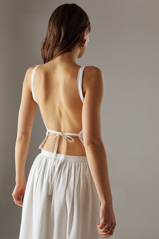 Sleek racer neckline with striking cross-back detail for a contemporary silhouette
        Cropped length perfect for high-waisted styling options
        Linen blend fabric offers breathable comfort with a natural texture
        Tie-back fastening allows for customisable fit
        Versatile design transitions effortlessly from day to evening wear
    
    This sophisticated crop top showcases a distinctive racer front with an eye-catching cross-back design that reveals just the right amount of skin. The textured linen blend fabric creates a refined yet relaxed aesthetic that's perfect for warm-weather styling. Pair with the matching wide-leg culottes as shown for a coordinated ensemble that radiates effortless chic, or style with high-waisted denim and strappy sandals for casual daytime events. For family gatherings or weekend brunches, layer with a lightweight cardigan and accessorise with statement earrings to enhance the look. The versatile nature of this piece makes it an essential addition to your summer wardrobe, offering countless styling possibilities whilst maintaining that confident Warehouse edge. The cropped silhouette works beautifully with higher-rise bottoms to create a balanced and flattering proportion.