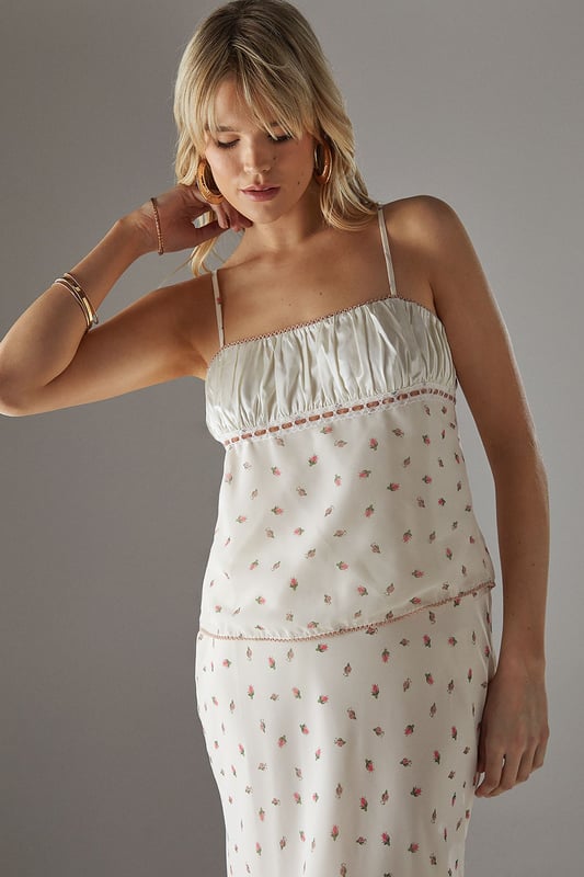 Feminine milkmaid-style top with delicate ruched bust detail
        Charming lace trim adds a touch of vintage-inspired elegance
        Adjustable thin straps for a personalised fit
        Dainty all-over pattern creates visual interest
        Back tie detail allows for customised styling
    
    This Warehouse ruched bust top captures the essence of carefree summer style with its romantic milkmaid silhouette. The delicate lace trim and ruched detailing create a feminine aesthetic that's both current and timeless. Perfect for daytime outings, style this versatile piece with your favourite denim and trainers for a casual coffee date, or pair with a flowing midi skirt and sandals for family gatherings. The loose fit offers comfortable wear throughout the day whilst maintaining a flattering shape. For cooler evenings, layer with a lightweight cardigan or denim jacket to extend its wearability. The adjustable straps and back tie detail allow you to customise the fit to your preference, making this top a wardrobe staple that transitions effortlessly from casual brunches to afternoon garden parties.