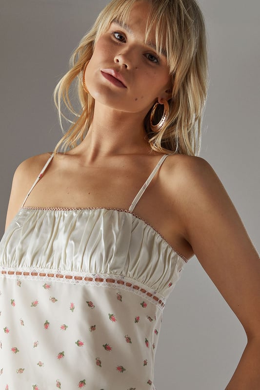 Feminine milkmaid-style top with delicate ruched bust detail
        Charming lace trim adds a touch of vintage-inspired elegance
        Adjustable thin straps for a personalised fit
        Dainty all-over pattern creates visual interest
        Back tie detail allows for customised styling
    
    This Warehouse ruched bust top captures the essence of carefree summer style with its romantic milkmaid silhouette. The delicate lace trim and ruched detailing create a feminine aesthetic that's both current and timeless. Perfect for daytime outings, style this versatile piece with your favourite denim and trainers for a casual coffee date, or pair with a flowing midi skirt and sandals for family gatherings. The loose fit offers comfortable wear throughout the day whilst maintaining a flattering shape. For cooler evenings, layer with a lightweight cardigan or denim jacket to extend its wearability. The adjustable straps and back tie detail allow you to customise the fit to your preference, making this top a wardrobe staple that transitions effortlessly from casual brunches to afternoon garden parties.