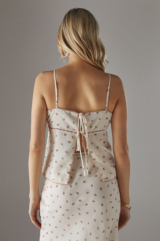 Feminine milkmaid-style top with delicate ruched bust detail
        Charming lace trim adds a touch of vintage-inspired elegance
        Adjustable thin straps for a personalised fit
        Dainty all-over pattern creates visual interest
        Back tie detail allows for customised styling
    
    This Warehouse ruched bust top captures the essence of carefree summer style with its romantic milkmaid silhouette. The delicate lace trim and ruched detailing create a feminine aesthetic that's both current and timeless. Perfect for daytime outings, style this versatile piece with your favourite denim and trainers for a casual coffee date, or pair with a flowing midi skirt and sandals for family gatherings. The loose fit offers comfortable wear throughout the day whilst maintaining a flattering shape. For cooler evenings, layer with a lightweight cardigan or denim jacket to extend its wearability. The adjustable straps and back tie detail allow you to customise the fit to your preference, making this top a wardrobe staple that transitions effortlessly from casual brunches to afternoon garden parties.