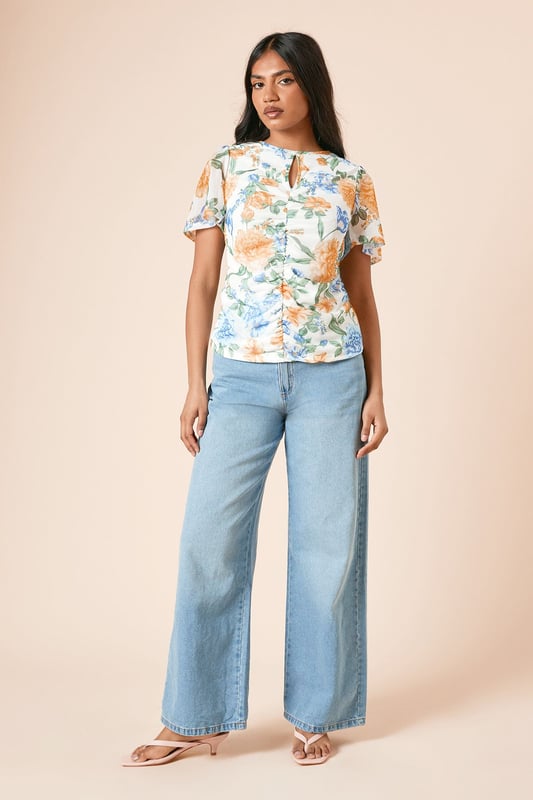 Delicate mesh fabric with floral print for a feminine touch
        Elegant keyhole detail at the neckline adds subtle interest
        Ruched front design creates a flattering silhouette
        Angel sleeves provide graceful movement and coverage
        Regular fit ensures comfortable wear for all-day events
    
    This charming mesh top from Dorothy Perkins combines comfort with style for the woman who appreciates subtle trends. The ruched front detail creates a figure-flattering effect whilst the angel sleeves offer a soft, feminine silhouette with just the right amount of coverage. Style this versatile piece with wide-leg denim as shown for casual brunches with friends, or pair with tailored trousers for family gatherings. The keyhole detail adds a touch of interest without revealing too much. Perfect for those who want to look put-together yet relaxed, this top transitions beautifully from daytime coffee dates to evening garden parties. Complete the look with simple flats and minimal jewellery for an effortlessly chic ensemble that reflects your personal style whilst maintaining comfort.