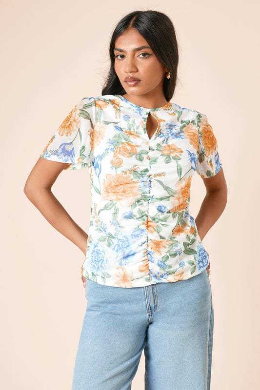 Delicate mesh fabric with floral print for a feminine touch
        Elegant keyhole detail at the neckline adds subtle interest
        Ruched front design creates a flattering silhouette
        Angel sleeves provide graceful movement and coverage
        Regular fit ensures comfortable wear for all-day events
    
    This charming mesh top from Dorothy Perkins combines comfort with style for the woman who appreciates subtle trends. The ruched front detail creates a figure-flattering effect whilst the angel sleeves offer a soft, feminine silhouette with just the right amount of coverage. Style this versatile piece with wide-leg denim as shown for casual brunches with friends, or pair with tailored trousers for family gatherings. The keyhole detail adds a touch of interest without revealing too much. Perfect for those who want to look put-together yet relaxed, this top transitions beautifully from daytime coffee dates to evening garden parties. Complete the look with simple flats and minimal jewellery for an effortlessly chic ensemble that reflects your personal style whilst maintaining comfort.