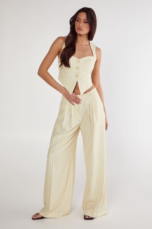Tailored vest with elegant pinstripe pattern throughout
        Structured sweetheart neckline with button-front closure
        Halter-style straps for a sophisticated silhouette
        Cropped length perfect for contemporary workwear styling
        Fitted design with subtle back detailing for a polished finish
    
    This Nasty Gal tailored vest reimagines office attire with contemporary flair. The structured silhouette and classic pinstripe pattern create a professional look whilst the cropped length and sweetheart neckline add a modern twist. Style with the matching wide-leg trousers as shown for a coordinated ensemble that commands attention in the boardroom. For a more versatile approach, pair with high-waisted tailored trousers and a crisp white shirt underneath. Complete your workwear look with minimal jewellery and pointed court shoes for meetings, or dress down with loafers for casual Friday. This versatile piece transitions seamlessly from day to evening - simply add statement earrings and a clutch bag for after-work gatherings. The vest's structured design flatters the figure whilst maintaining workplace appropriateness.