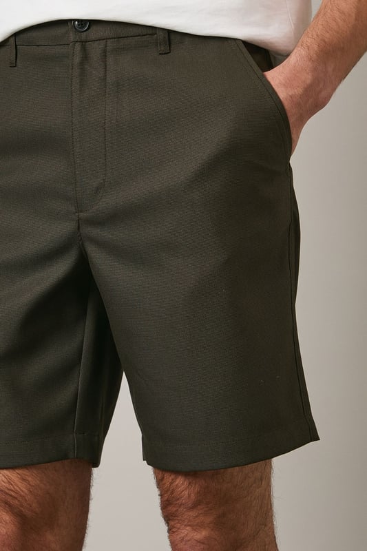 Textured chino shorts with a clean-cut silhouette for a refined casual look
        Classic flat front design with side pockets for practicality
        Mid-thigh length offering comfortable coverage for warm-weather wear
        Belt loops provide styling versatility to suit your personal taste
        Tailored waistband with button fastening ensures a secure and comfortable fit
    
    These Maine textured chino shorts combine comfort with understated style for your casual wardrobe. The versatile design makes them perfect for weekend outings, garden parties or relaxed family gatherings. Style them as shown with a crisp white t-shirt and patterned short-sleeve shirt for an effortlessly coordinated look, or pair with a simple polo for more laid-back occasions. The neutral tone works brilliantly with loafers or boat shoes for a smart-casual approach, while trainers create a more relaxed aesthetic. These shorts transition seamlessly from daytime casual to evening barbecues - simply add a lightweight knit when temperatures drop. Their adaptable nature makes them an essential component for building numerous summer outfits with minimal effort.